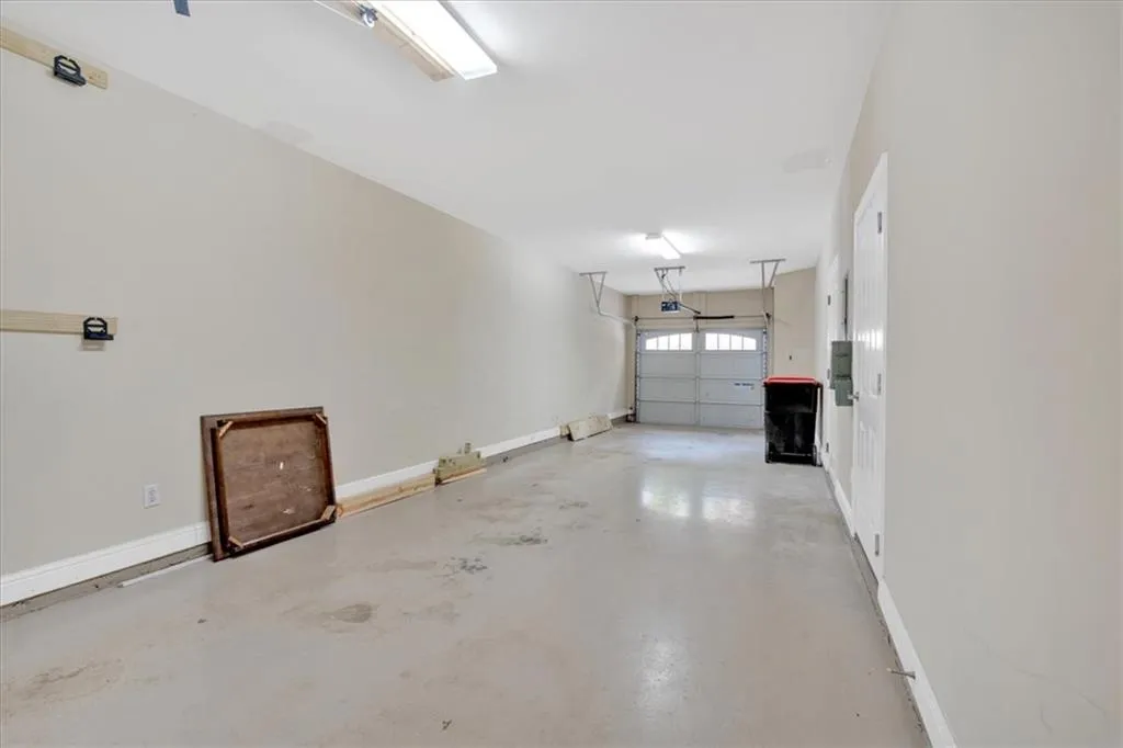 Garage with baseboards and a garage door opener