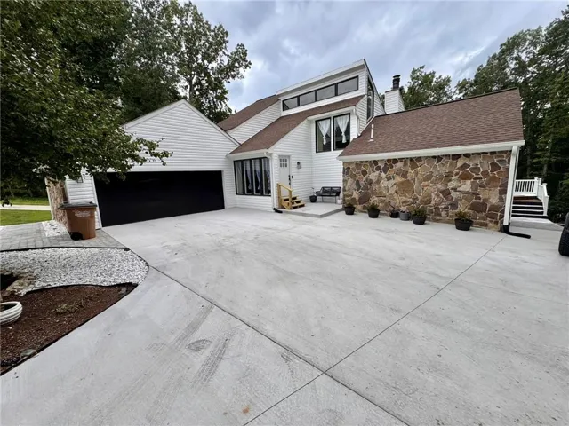 Modern exterior featuring white siding and natural stone accents