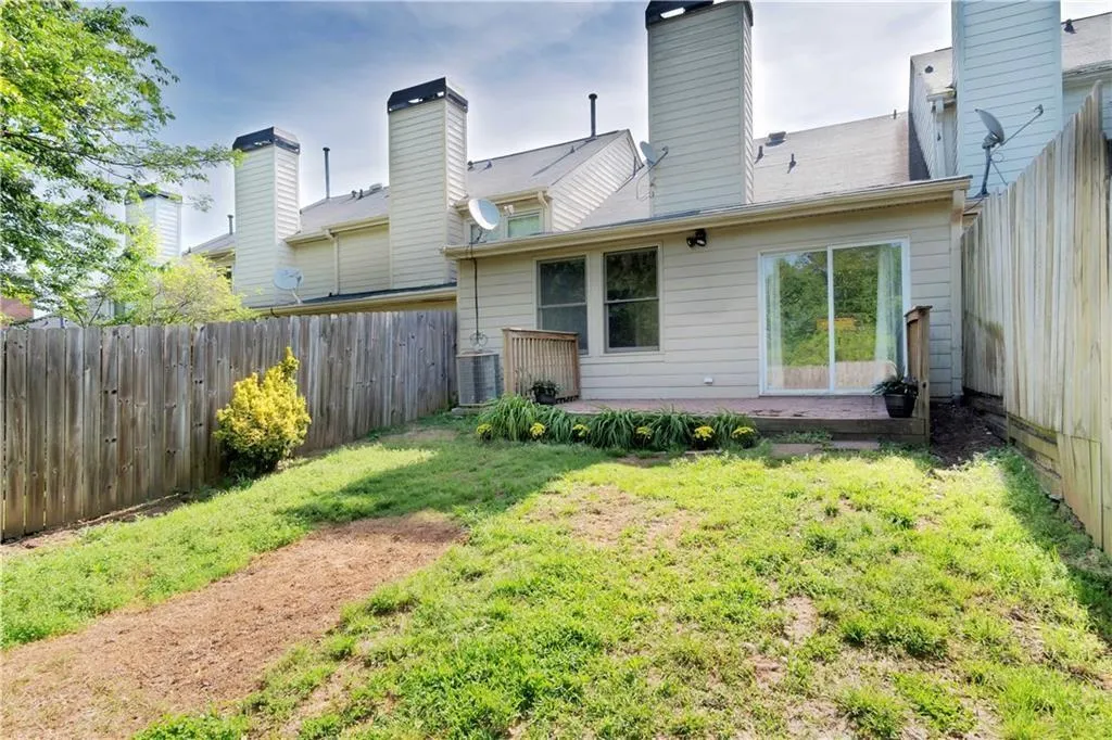 Back of property featuring a yard, a fenced backyard, and a chimney