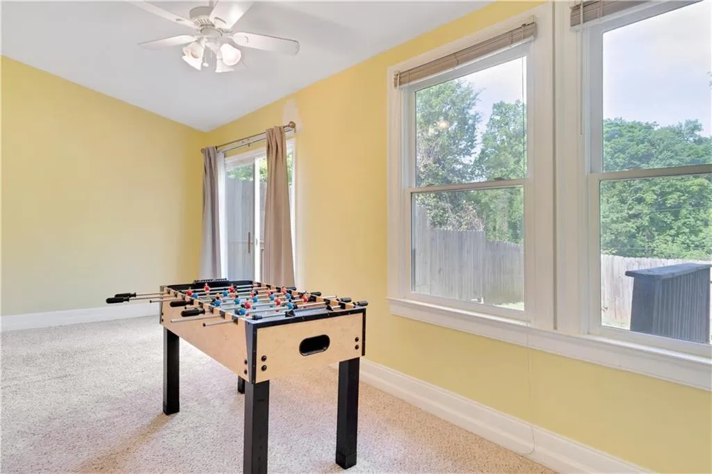 Playroom featuring carpet flooring, a ceiling fan, and baseboards
