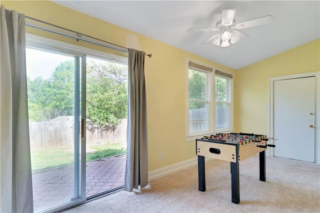 Game room with lofted ceiling, carpet flooring, a ceiling fan, and baseboards