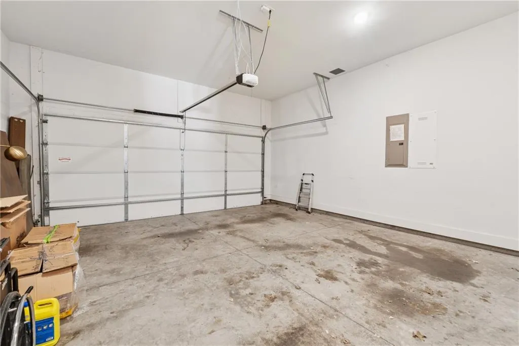 Garage featuring a garage door opener and electric panel