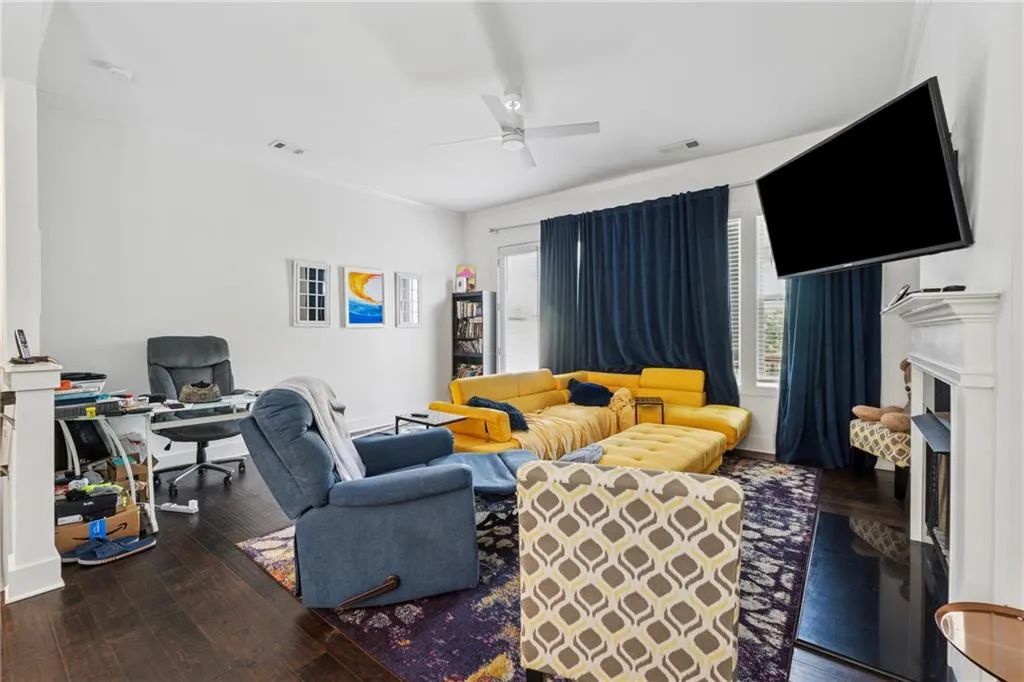 Living area featuring a ceiling fan and wood-type flooring