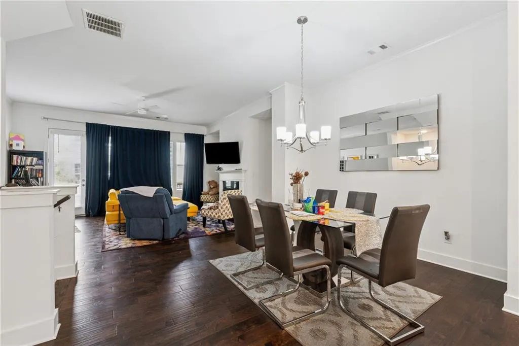 Dining area featuring a chandelier, hardwood / wood-style floors, ornamental molding, a fireplace, and ceiling fan