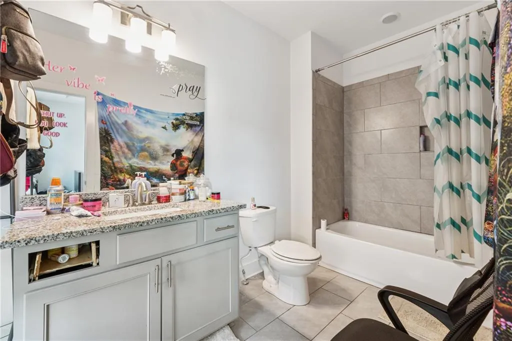 Full bathroom with vanity, tile patterned floors, and shower / bath combo with shower curtain
