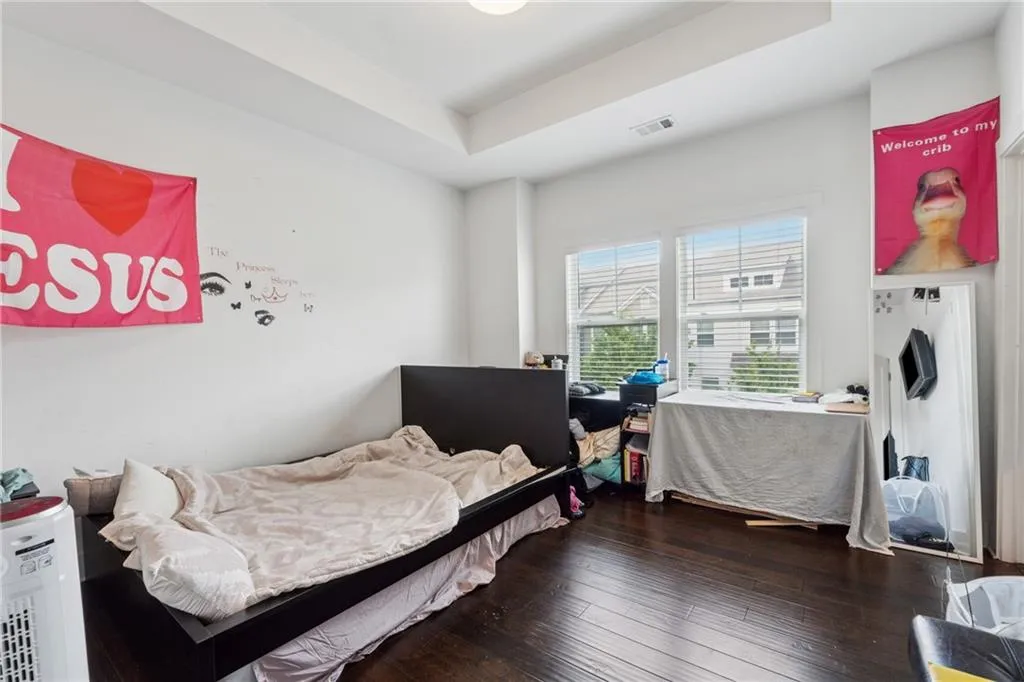 Bedroom featuring a tray ceiling and hardwood / wood-style flooring