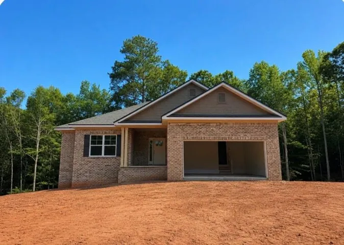 Brick exterior with a covered porch, attached two-car garage, and gabled rooflines
