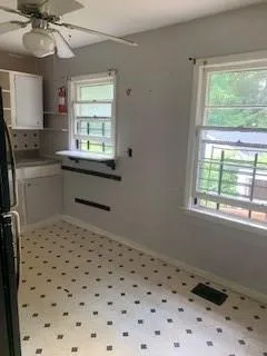 Kitchen with white cabinetry, open shelves, a ceiling fan, and fridge