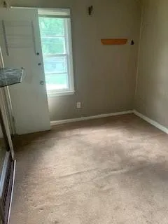 Spare room featuring carpet floors and baseboards