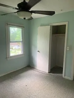 Unfurnished bedroom with a closet, carpet flooring, and ceiling fan
