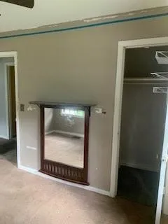 Unfurnished bedroom featuring carpet flooring, a walk in closet, and crown molding