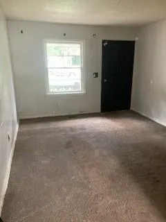 Empty room featuring carpet floors and baseboards