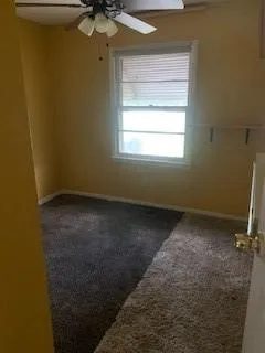 Empty room with carpet floors and ceiling fan