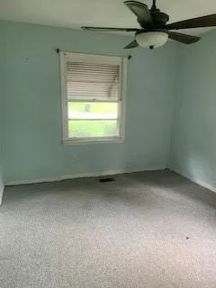 Unfurnished room featuring carpet floors and ceiling fan