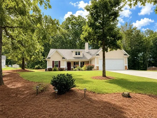 Single-story residence featuring light-toned siding, a covered front porch, and a two-car garage