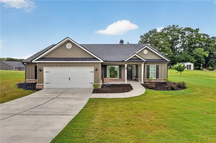Ranch-style exterior with a two-car garage and a concrete driveway
