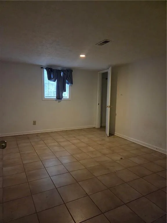 Extra room in basement with tile flooring and recessed lighting