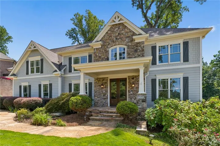 Welcome to 385 Pandemar Trail graciously offering a stone-paved walkway which winds through beautifully manicured landscaping, welcoming you to the inviting front porch with beautiful wood French Doorsl! The striking exterior blends timeless cedar siding with natural stacked-stone accents, crisp architectural details, and an elegant architectural roofline. A spacious side-loaded garage adds both convenience and curb appeal, while the covered front porch creates a warm and welcoming entry—an ideal introduction to the exceptional home beyond.
