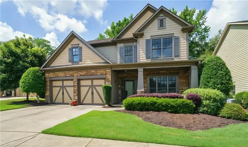 Two-story exterior with stone and siding accents, prominent gables, and decorative shutters