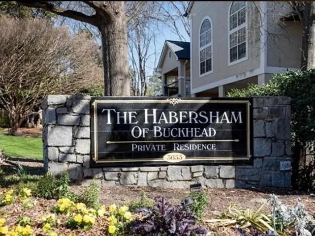 Stone-clad monument sign with a black and gold plaque