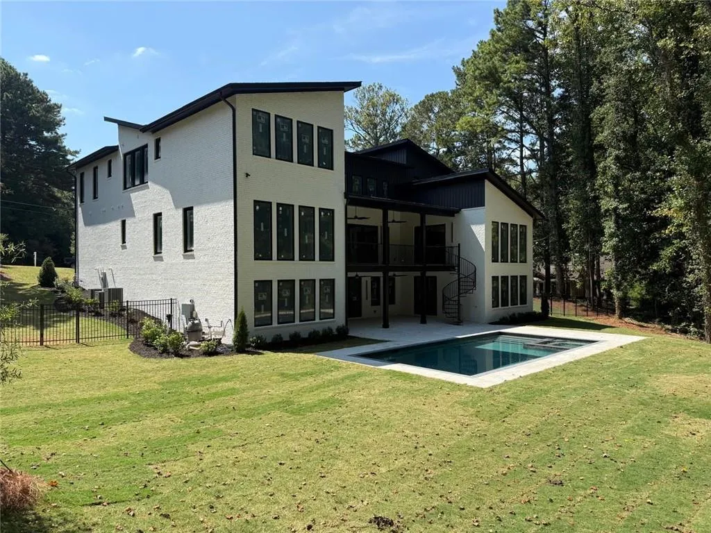 Back of property featuring a balcony, a ceiling fan, a patio, and stairway
