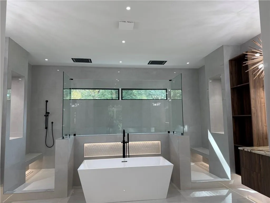 Bathroom featuring plenty of natural light, a soaking tub, a walk in shower, recessed lighting, and tile walls Bathroom featuring plenty of natural light, a soaking tub, a walk in shower, recessed lighting, and tile walls