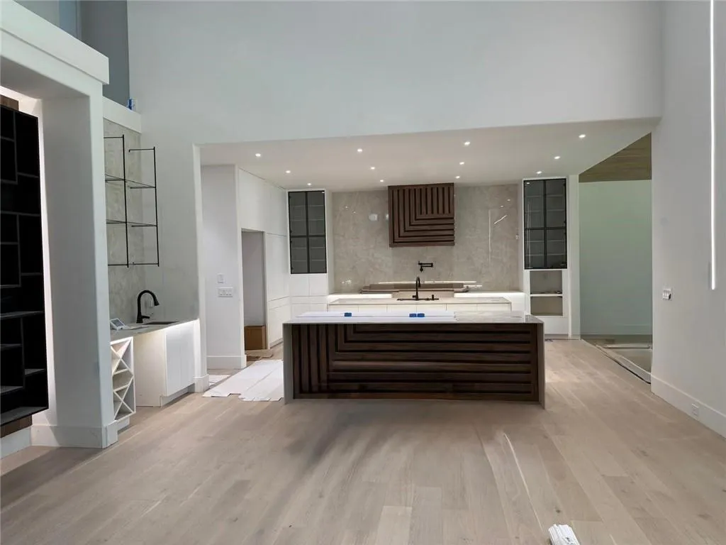 Full bath featuring light wood-style floors, decorative backsplash, recessed lighting, a towering ceiling, and vanity