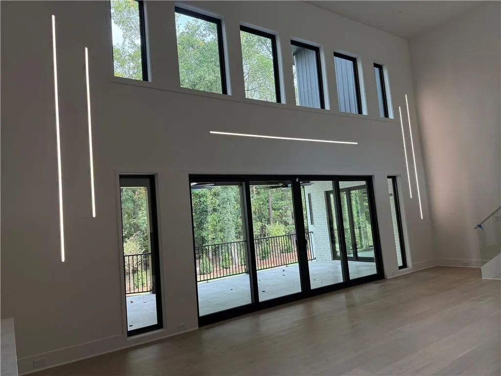 Entryway with healthy amount of natural light, wood finished floors, and a high ceiling
