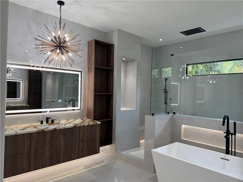 Bathroom with vanity, a freestanding bath, a walk in shower, light tile patterned floors, and a chandelier Bathroom with vanity, a freestanding bath, a walk in shower, light tile patterned floors, and a chandelier