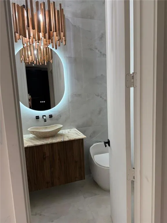 Bathroom featuring tile walls and vanity