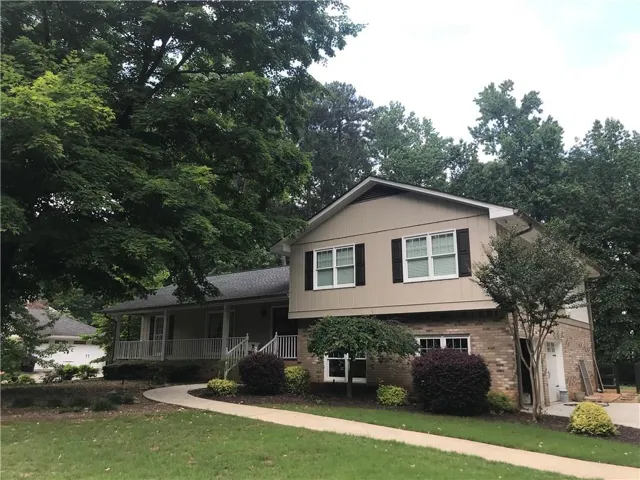 Tri-level home featuring a front lawn and covered porch