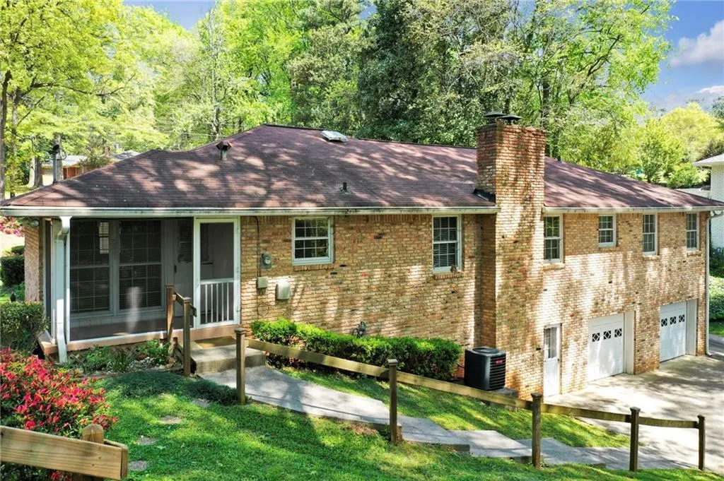 View of back of property with central AC unit, a front lawn, and a garage