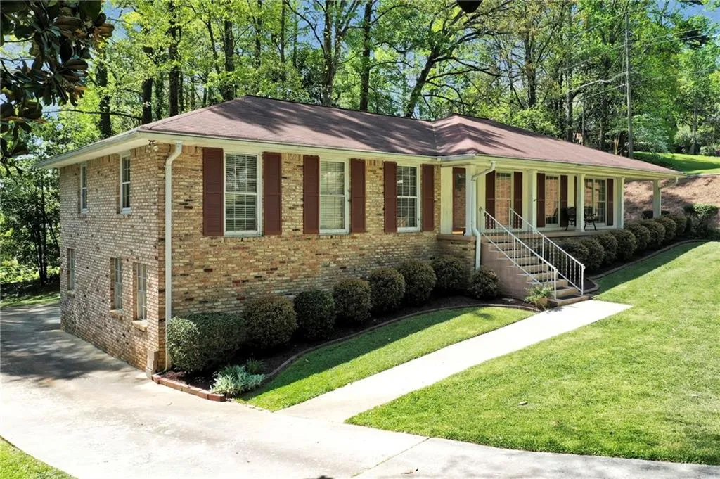 Ranch-style home featuring covered porch and a front lawn