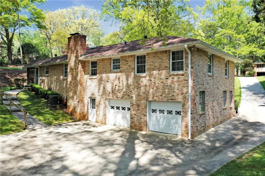 View of back of home featuring central AC unit and a garage