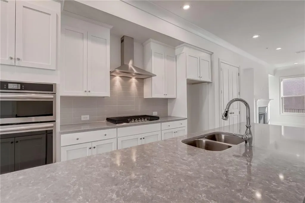 Beautiful white cabinetry in this kitchen with upgrade quartz countertops and pendant lighting over the island.
