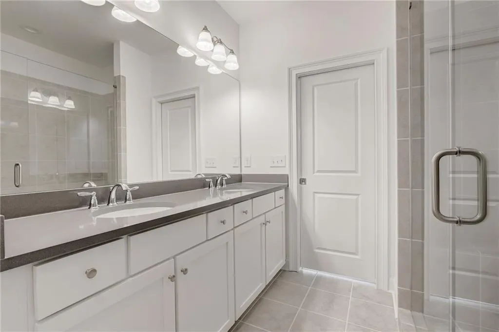 The spa-like shower in the Primary Bath has frameless doors and upgrade tile with shower seat!