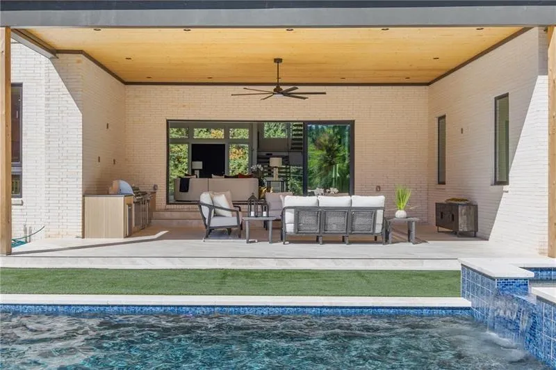 Back covered patio with gas Blaze grill, 2 gas burners, beverage refrigerator, trash and storage.
