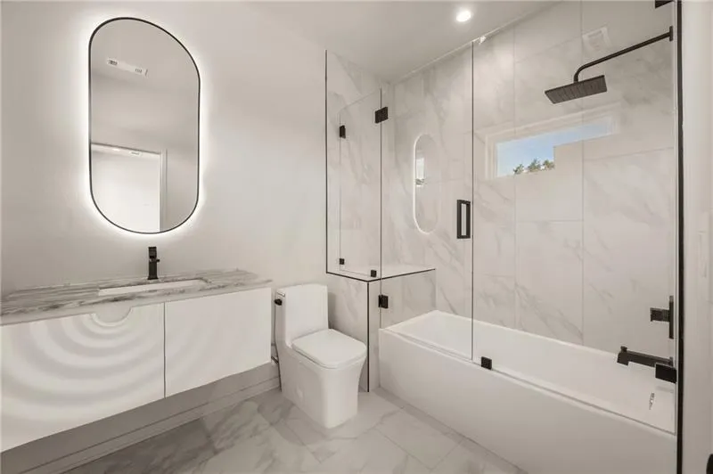 Full bath with vanity, combined bath / shower with glass door, and marble finish floors