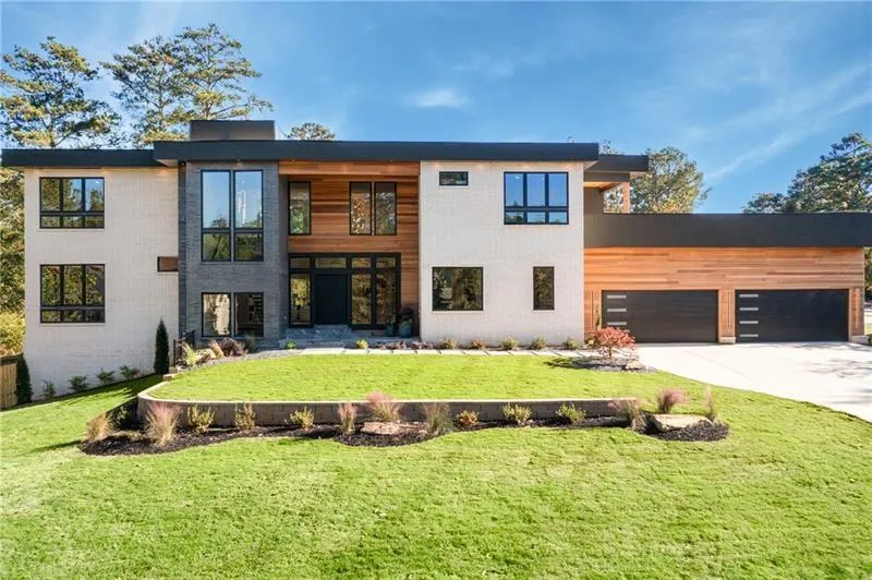 View of front of house featuring concrete driveway, a front yard, and a garage