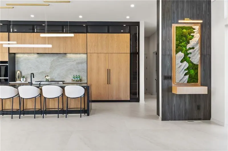 Kitchen featuring modern cabinets, double oven, and a breakfast bar area