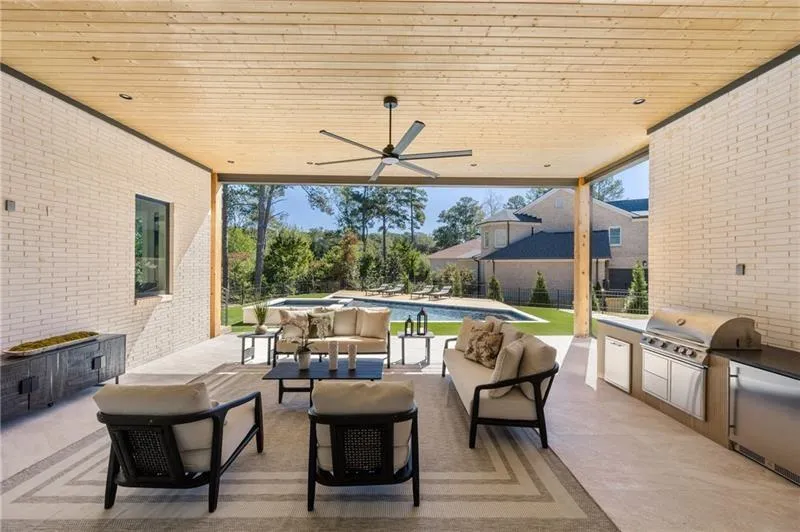 View of patio featuring an outdoor kitchen, a ceiling fan, and outdoor lounge area