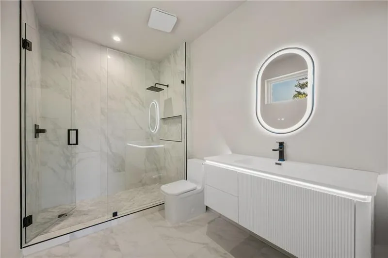 Bathroom featuring marble finish flooring, vanity, a marble finish shower, and recessed lighting