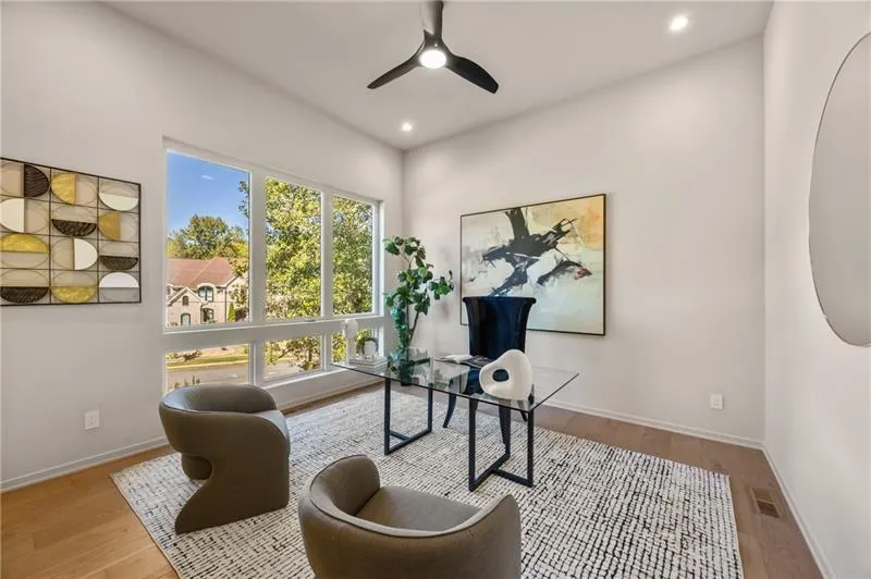 Home office or additional bedroom on the main level with wood finished floors, a ceiling fan, and recessed lighting and built in closet.