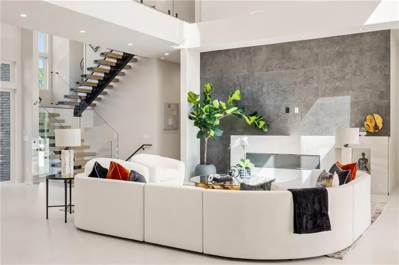 Living area featuring an accent wall, stairway, recessed lighting, and a high ceiling