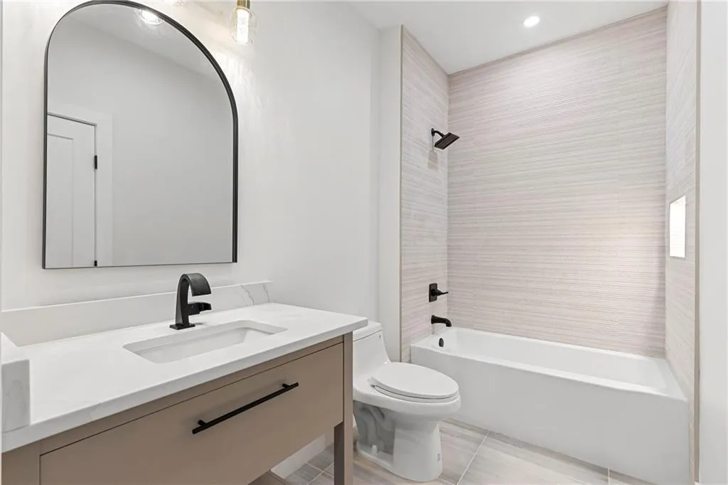 Bathroom with shower / bath combination, vanity, and recessed lighting