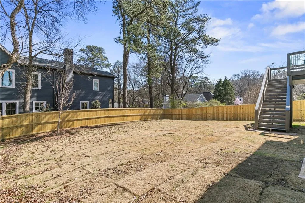 Fenced backyard with stairway and a deck