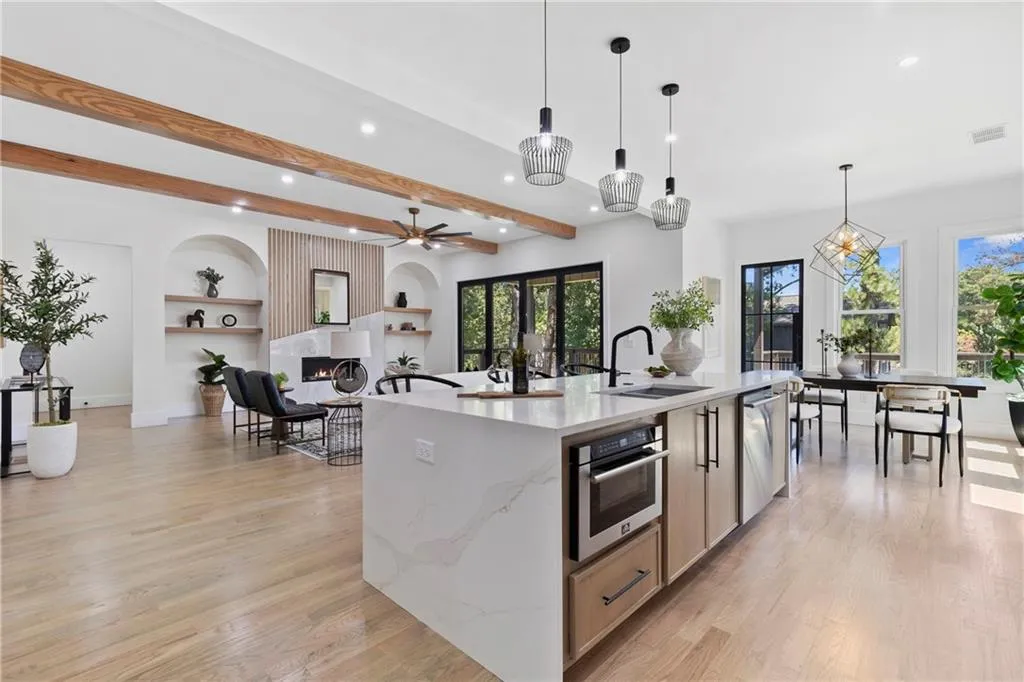 Kitchen with decorative light fixtures, light stone countertops, beamed ceiling, recessed lighting, and light wood finished floors