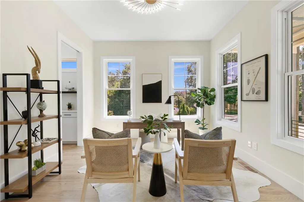 Living area with light wood-style flooring, healthy amount of natural light, and a chandelier
