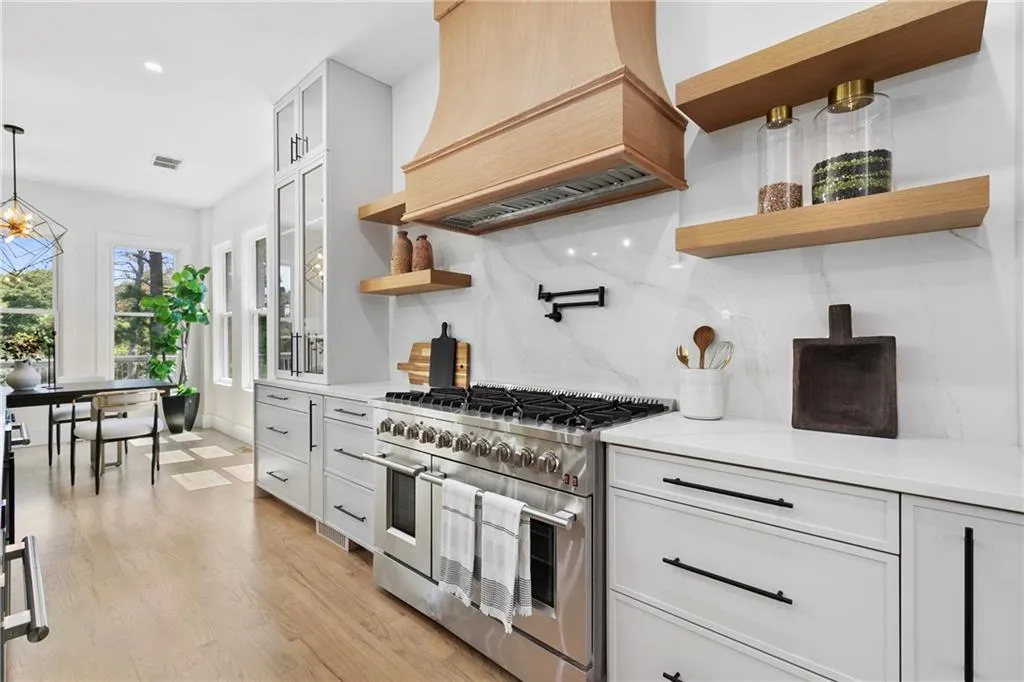 Kitchen with open shelves, white cabinetry, high end range, tasteful backsplash, and recessed lighting