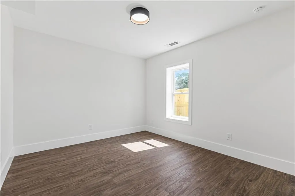 Spare room featuring dark wood finished floors and baseboards
